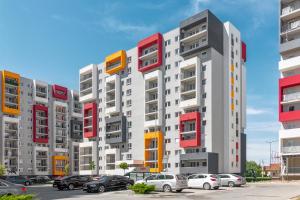 a tall building with colorful windows and cars parked in a parking lot at Park View in Oradea