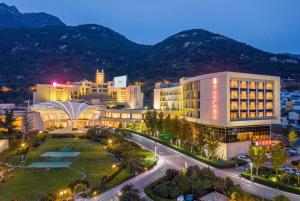 a city at night with mountains in the background at Ramada Plaza Taian in Tai'an