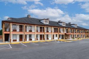 a large building with a parking lot in front of it at Baymont by Wyndham Commerce GA Near Tanger Outlets Mall in Commerce