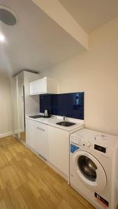 cocina con lavadora y fregadero en Seaview 2 room Apartment, en Batumi