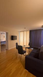 sala de estar con sofá, mesa y sillas en Seaview 2 room Apartment, en Batumi