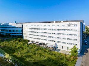 a large white building with a park in front of it at Novotel Nantes Centre Gare in Nantes