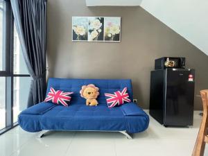 a teddy bear sitting on a blue couch with pillows at Pacific Tower Petaling Jaya Near Jaya One, University Malaya, Columbia Hospital By My Homez in Petaling Jaya