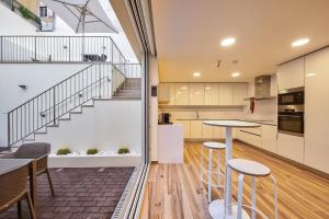 uma cozinha em plano aberto e sala de jantar com uma escada numa casa em Avenue Garden em Coimbra