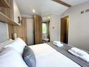 1 dormitorio con 1 cama con toallas en Pass the Keys Gorgeous Kippford Home With Outstanding Views, en Kippford