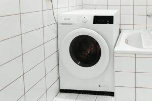 uma máquina de lavar roupa na casa de banho ao lado de um lavatório em Magdeburg Wohnkomfort - Vollausgestattet - Streaming - Familie & Business em Magdeburg