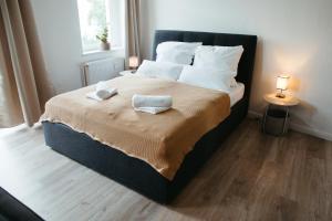 um quarto com uma cama grande com duas toalhas em Magdeburg Wohnkomfort - Vollausgestattet - Streaming - Familie & Business em Magdeburg