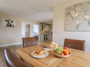 a wooden table with two plates of food on it at Bramley Cottage in Clacton-on-Sea