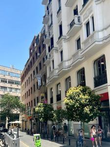 Un gruppo di persone che camminano per una strada di fronte a un edificio di Hostal Milan a Madrid