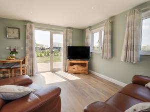 - un salon avec un canapé et une télévision dans l'établissement Pippin Cottage, à Clacton-on-Sea