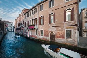 a boat in a canal in front of buildings at Ca' Gottardi in Venice