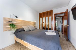 1 dormitorio con 1 cama grande y cabecero de madera en MalagaSuite Cozy Stay Malaga en Málaga