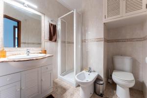 Baño blanco con aseo y lavamanos en MalagaSuite Cozy Stay Malaga en Málaga