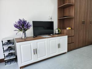 ein weißer Schrank mit einem Fernseher darüber in der Unterkunft Starfish house in Nghi Xuân