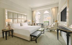 a bedroom with a large white bed and a desk at Párisi Udvar Hotel Budapest, part of Hyatt in Budapest