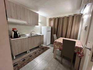 Una pequeña cocina con una mesa y un refrigerador. en Case Vacanze Seggettieri, en Palermo