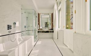 un bagno bianco con vasca e lavandino di Párisi Udvar Hotel Budapest, part of Hyatt a Budapest