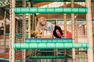 Ein junges Mädchen spielt auf einem Trampolin in der Unterkunft Momentum Hotel in Anif