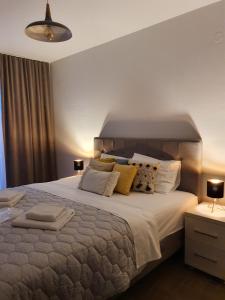 ein Schlafzimmer mit einem großen Bett mit weißer Bettwäsche und Kissen in der Unterkunft Djukic Winery in Podgorica