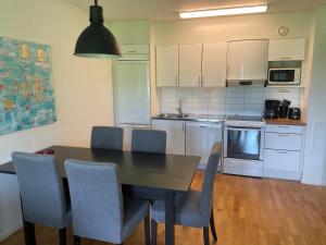 a kitchen with a dining room table and chairs at Ljusnedal lägenhet med golf, paddel, fiske och skidåkning in Ljusnedal
