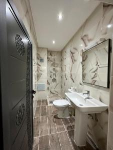 La salle de bains est pourvue d'un lavabo, de toilettes et d'un miroir. dans l'établissement Hôtel Zaghro, à Ouarzazate