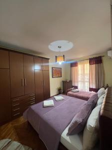 a bedroom with a large bed with two towels on it at Apartament Qender in Elbasan