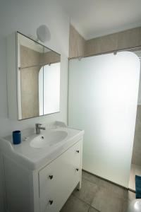 プンタ・ムヘーレスにあるCasa La Sebaの白いバスルーム(シンク、鏡付)
