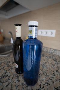 Casa La Seba في بونتا موخيريس: زجاجة من الزجاج الأزرق بجوار زجاجة من النبيذ