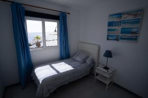 a bedroom with a bed and a window with a view of the beach at Casa La Seba in Punta de Mujeres