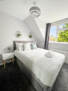 a white bedroom with a large bed and a window at The Reading Gem in Reading