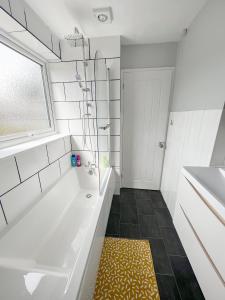 a white bathroom with a tub and a sink at The Reading Gem in Reading