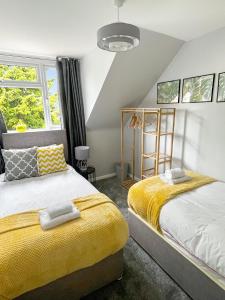 1 Schlafzimmer mit 2 Betten und gelben Decken in der Unterkunft The Reading Gem in Reading