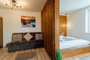 利普托斯基米庫拉斯的住宿－Miracle Seasons，一间卧室配有一张床和一张沙发