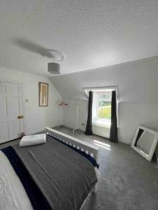 a bedroom with a large bed and a window at Isla’s Cottage in Stornoway