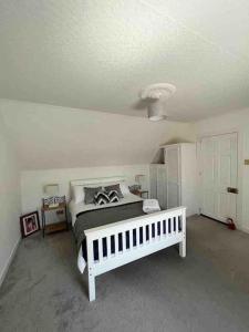 a bedroom with a white bed and a white ceiling at Isla’s Cottage in Stornoway