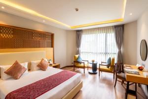 una camera d'albergo con letto e scrivania di Hotel Pokhara Grande a Pokhara