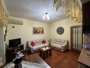 a living room with two couches and a tv at Apartament Qender in Elbasan