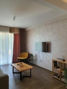 ein Wohnzimmer mit einem Sofa und einem TV an der Wand in der Unterkunft Djukic Winery in Podgorica