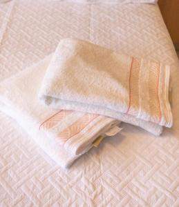 una pila de toallas sentadas encima de una cama en FS Confort - Flat Residence Mar, en João Pessoa