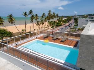 una piscina en la parte superior de un edificio junto a la playa en FS Confort - Flat Residence Mar, en João Pessoa