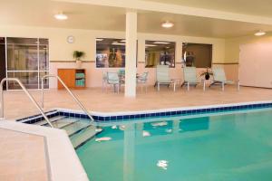 a pool with chairs and a table in a building at SpringHill Suites by Marriott Wisconsin Dells in Wisconsin Dells
