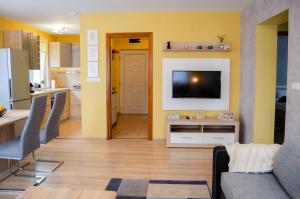 een woonkamer met een televisie en een keuken bij Bodó apartman 2 in Hévíz