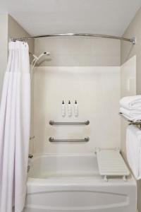 a bathroom with a shower and a white shower curtain at SpringHill Suites Phoenix Tempe Airport in Tempe