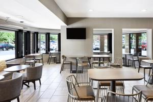 un restaurante con mesas y sillas y TV de pantalla plana en SpringHill Suites Phoenix Tempe Airport, en Tempe