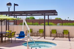 a patio with a pool and chairs and a table at SpringHill Suites Phoenix Tempe Airport in Tempe