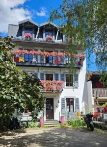 a white building with flower boxes on the balconies at Hotel Du Clocher in Chamonix-Mont-Blanc