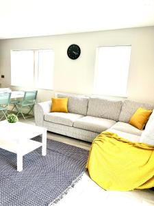 a living room with a couch and a table at Deluxe 2 Bed 2 Bath Flat - Windsor, Heathrow Airport, Slough Station in Slough