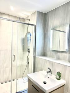 a bathroom with a shower and a sink at Deluxe 2 Bed 2 Bath Flat - Windsor, Heathrow Airport, Slough Station in Slough