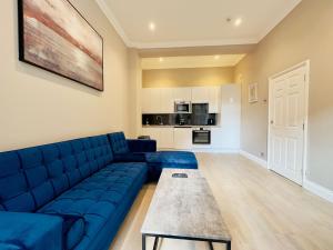 a living room with a blue couch and a table at Super Central One Bedroom Flat Next To Brighton Beach in Brighton & Hove