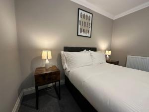 1 dormitorio con 1 cama y 1 mesa con lámpara en Super Central One Bedroom Flat Next To Brighton Beach, en Brighton & Hove